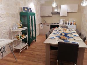 a kitchen with a long table with chairs and a kitchen at B&B La Grotta in Nicolosi