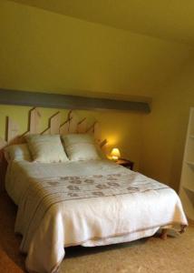 a bedroom with a large bed with white sheets and pillows at Chambres chez L’habitant in Couvin