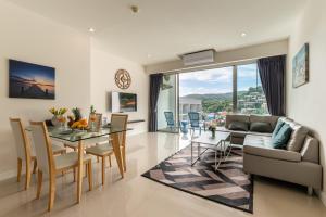 a living room with a table and a couch at Chic Condo in Karon Beach