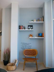uma cadeira sentada numa sala com prateleiras em NYC Modern & Spacious Apartament 5 min from seaside em Orikum