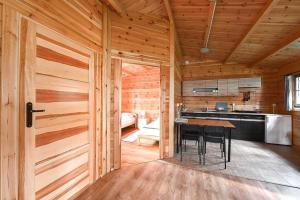 a kitchen with a table in a wooden cabin at Leśniczówka-Wdzydze Pe eL in Wdzydze Kiszewskie +49 photos