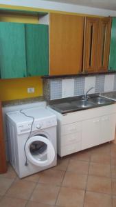 a kitchen with a washing machine and a sink at Vendicari in Pachino