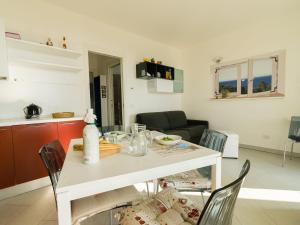 un tavolo bianco e sedie in soggiorno di Borgo dei Fiori - relax and sea view with swimming pool a Magliolo