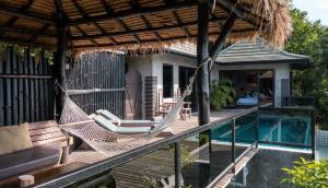 a hammock on a deck next to a swimming pool at Koh Tao Heights Pool Villas in Ko Tao
