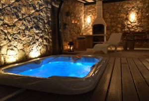 uma banheira de hidromassagem num quarto com uma parede de pedra em PANORAMA PLUS em Njivice