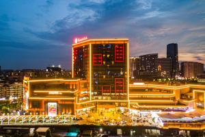 ein hohes Gebäude mit roten Lichtern in der Nacht in der Unterkunft Ramada Foshan Nanhai in Nanhai