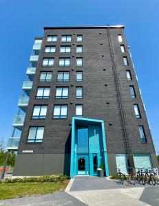 a tall building with a blue door at The River 31, Baritoni in Pori