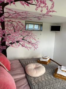 a room with a bed with a tree mural on the wall at B&B Bijzonder in Drachten