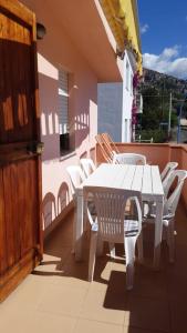 a white table and chairs on a balcony at Casa Lucia Relax in Cala Gonone