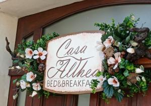 um sinal numa porta com flores em B&B Casa Althea em Milo