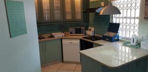 - une cuisine avec des murs carrelés verts et un comptoir dans l'établissement Marina Glen 12, à Ramsgate