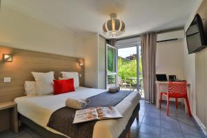een hotelkamer met een groot bed en een balkon bij The Originals Boutique, Hôtel Le Cap, Gap Sud in Tallard