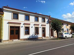 un edificio bianco sul lato di una strada di Shiny Star Apartmán a Spišská Nová Ves