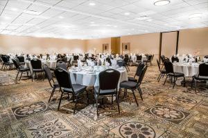 um salão de banquetes com mesas e cadeiras brancas em Norwood Inn & Suites La Crosse em La Crosse
