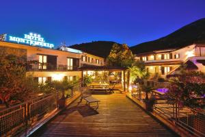 a wooden walkway leading to a hotel at night at Eco Hotel Montemerlo in Fetovaia
