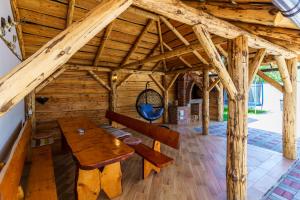 um grande quarto de madeira com uma mesa de madeira e bancos em Casa Primaverii em Rasnov