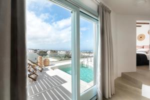 a room with a balcony with a view of the ocean at Santo Bloom Luxury Villas in Vóthon