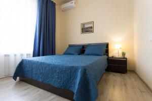 a bedroom with a bed with blue sheets and a window at Modern apartments in the Centre - Kuznechna str. 26/4 in Kharkiv