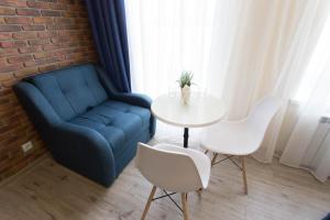 sala de estar con sofá azul, mesa y sillas en Modern apartments in the Centre - Kuznechna str. 26/4, en Járkov