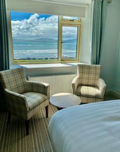 a hotel room with a bed and two chairs and a window at Seaclusion Luxury Guest Accommodation in Waterville