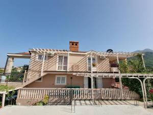 une maison avec une terrasse couverte et un balcon dans l'établissement Apartments Popadić with parking, à Herceg-Novi