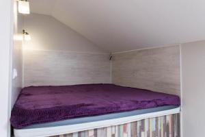 een bed in een kleine kamer met een paars matras bij New apartments near the Constitution Square - Kuznechna str. 26/5 in Charkov