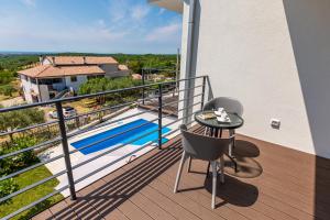 a balcony with a table and a view of a pool at Villa Fortuna by Rent Istria in Buje +40 photos