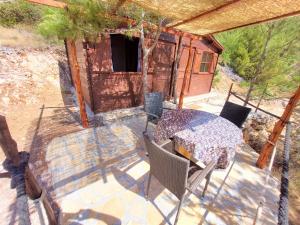 eine Terrasse mit einem Tisch und Stühlen sowie ein Haus in der Unterkunft Vala Hrvaska Robinson in Gornji Humac