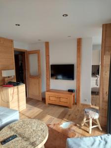 un salon avec une télévision et une table dans l'établissement Le grand cerf le Pelvou, à Vars