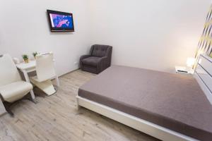 a bedroom with a bed and a chair and a table at New apartments in the city center - Kuznechna str. 26/1 in Kharkiv