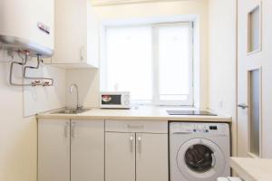 a kitchen with a washing machine and a window at New apartments in the city center - Kuznechna str. 26/1 in Kharkiv