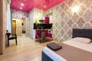 une chambre avec un lit et une cuisine avec des plafonds roses dans l'établissement Studio apartment in the Center - Heroiv Nebesnoi Sotni sq. 21/7, à Kharkov