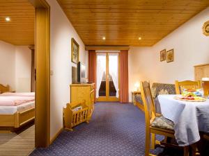 1 dormitorio con cama, mesa y TV en Gasthof-Ferienwohnungen Dürrlehen, en Berchtesgaden