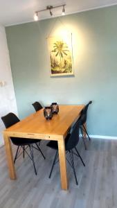 einen Esstisch mit Stühlen und ein Gemälde an der Wand in der Unterkunft Plattedijk - vakantiehuis 25-41 in Lemmer