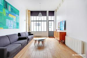 uma sala de estar com um sofá e uma mesa em CMG Faubourg Saint-Martin em Paris