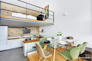 uma cozinha e sala de jantar com uma mesa de vidro e cadeiras em CMG Faubourg Saint-Martin em Paris