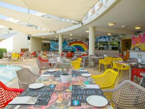 a restaurant with tables and chairs and a pool at St Raphael Resort in Limassol