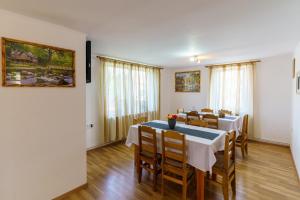a dining room with tables and chairs and windows at Casa Primaverii in Râşnov