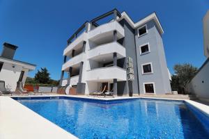 a building with a swimming pool in front of it at Villa Mariella in Novalja