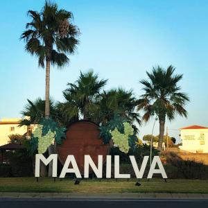 un signo de manila con palmeras en el fondo en Große Ferienwohnung , Spanien, Andalusien, Costa del Sol mit Pool, en San Luis de Sabinillas