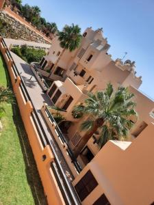 una casa grande con palmeras delante en Große Ferienwohnung , Spanien, Andalusien, Costa del Sol mit Pool, en San Luis de Sabinillas