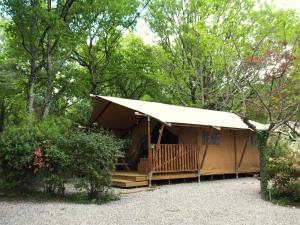 a large tent with a porch in the woods at camping mas du sartre in Auriolles