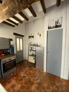 een keuken met een koelkast en een deur erin bij La porte de l'eau Piscine chauffée et jacuzzi in Saint-Auban-sur-lʼOuvèze