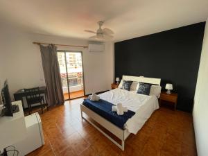 a bedroom with a large bed and a large window at Hostal Baleàric in San Antonio