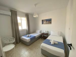 1 Schlafzimmer mit 2 Betten, einem Tisch und einem Fenster in der Unterkunft Galtheo in Lachi