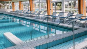 a swimming pool with chairs in a building at MClub Alicudi in Sciacca