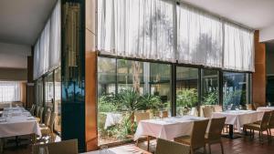 un ristorante con tavoli e sedie e una grande finestra di MClub Alicudi a Sciacca