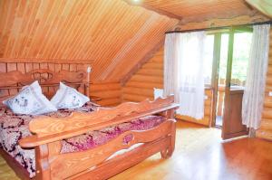 a bedroom with a bed in a log cabin at Садиба Курортна in Zhdenievo