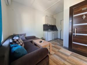 a living room with a couch and a table at Бунгала Калина - Нестинарка in Tsarevo