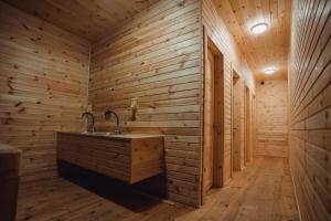 uma casa de banho com um lavatório numa parede de madeira em Glamping Mandra Kanev em Leplyavo
